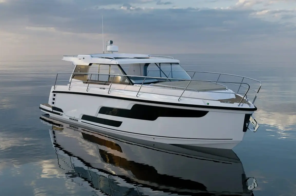 A sleek white motorboat with a modern design anchored on calm waters, reflecting clouds in a serene setting.